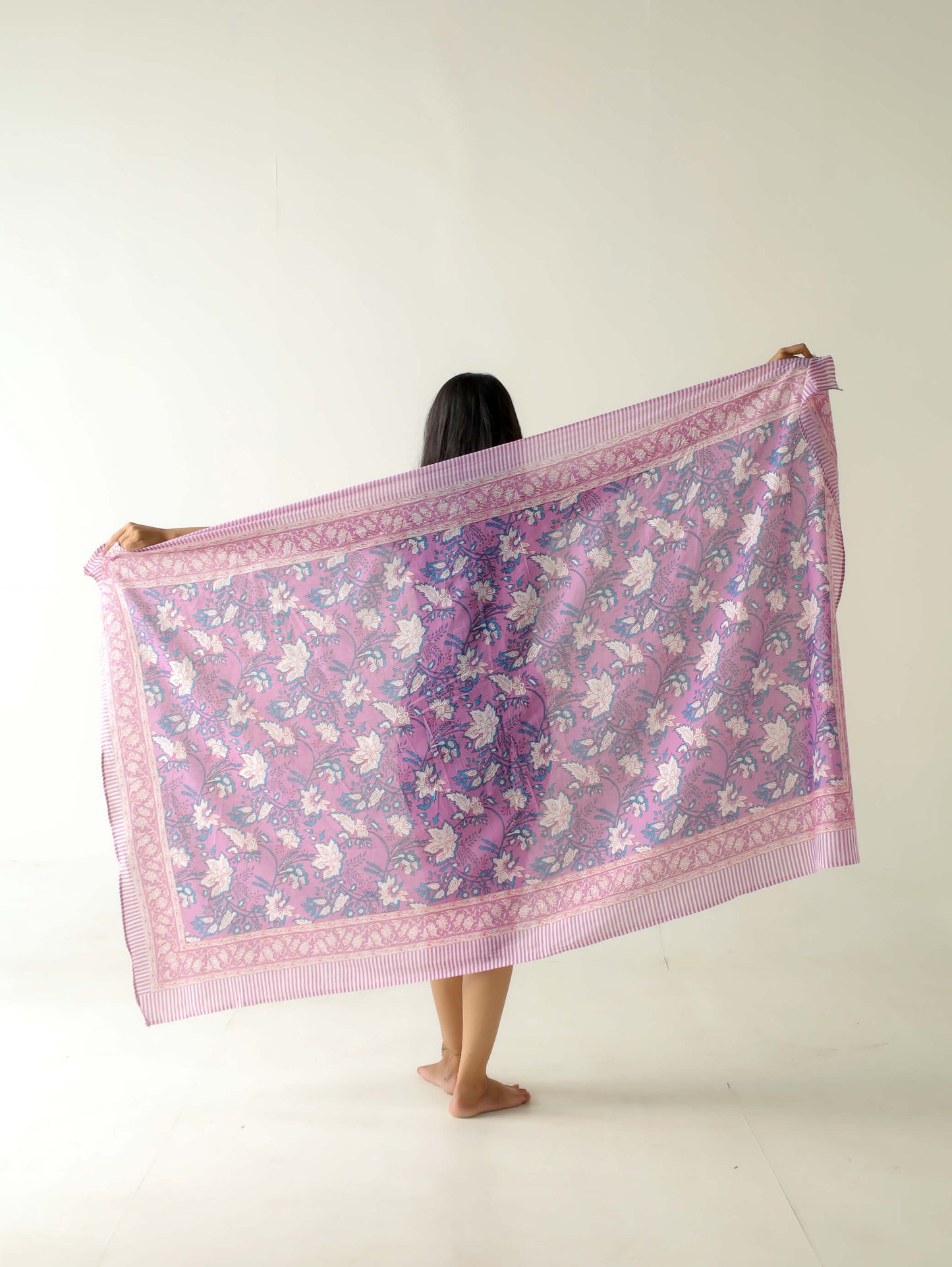 mostrando pareo lila artesanal con diseño boho chic en tonos lilas y rosados